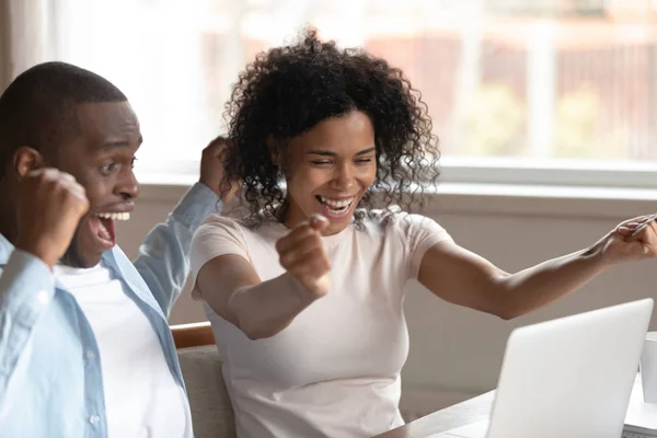 Emocionada pareja afroamericana llena de noticias en el ordenador portátil — Foto de Stock