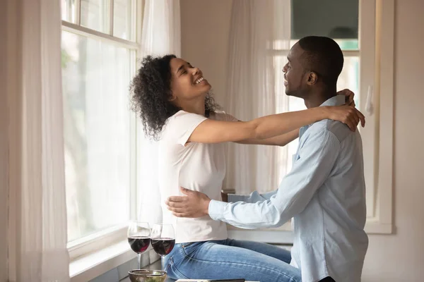 Loving biracial couple enjoy dinner date in kitchen — Stock Photo, Image