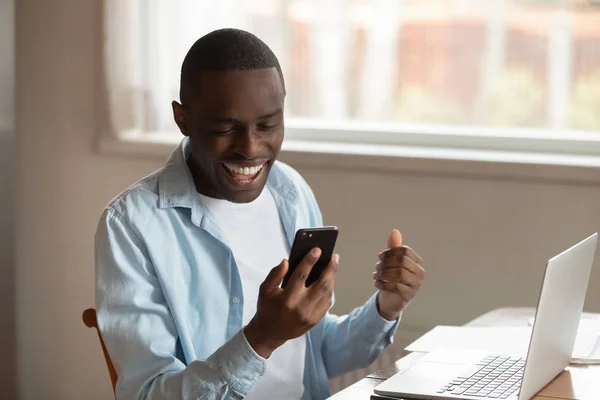 Excitado biracial homem sentir-se muito feliz com boas notícias no celular — Fotografia de Stock