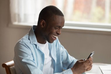 Overjoyed biracial adam akıllı telefonda coşkulu mesajlaşma hissediyorum