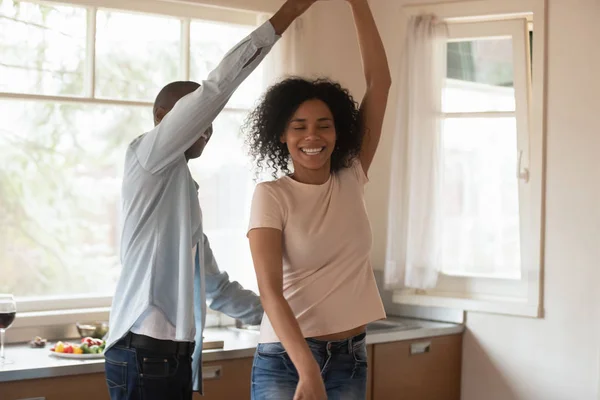 Feliz biracial pareja bailando en cocina disfrutando de fecha —  Fotos de Stock