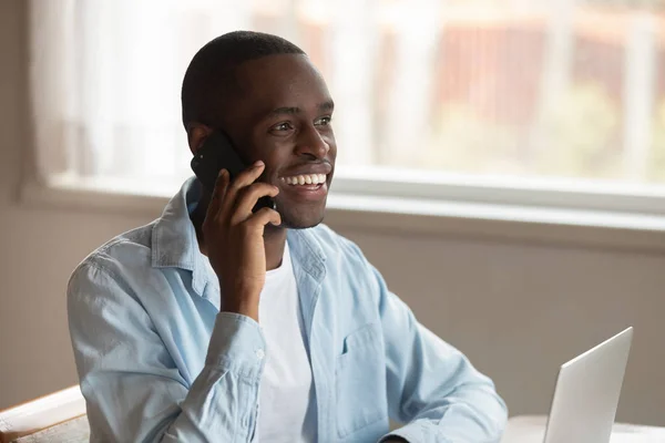 Uśmiechnięty biracial człowiek śmiać się mający telefon rozmowa — Zdjęcie stockowe