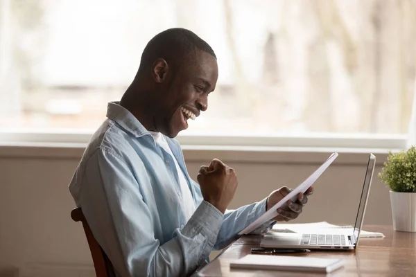 Upphetsad biracial man känner euforisk läsning positiv skrivelse — Stockfoto