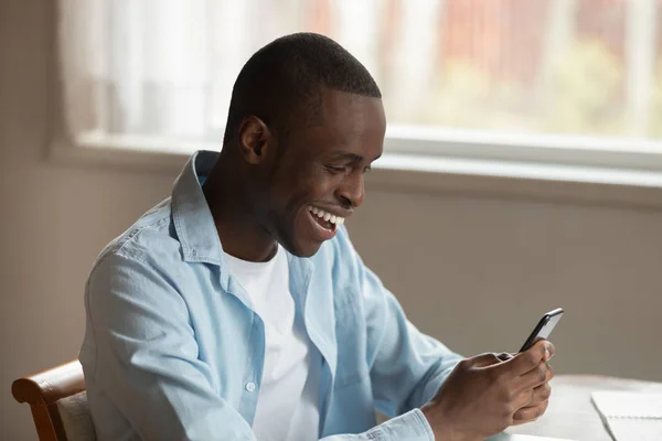 Overjoyed biracial homem sentir eufórico mensagens de texto no smartphone — Fotografia de Stock