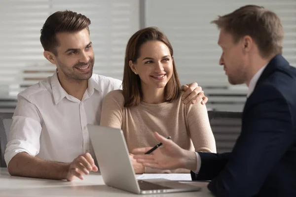 Sonriente pareja consultando con asesor financiero o agente de bienes raíces . — Foto de Stock