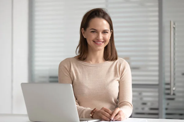 Hoofdschot portret van zakenvrouw zittend op kantoor met laptop. — Stockfoto