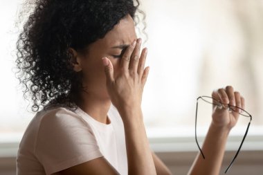 Bitkin biracial kadın migren muzdarip gözlük çıkarmak