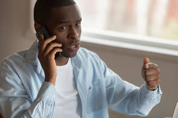 Insatisfecho biracial hombre teniendo desagradable celular conversación — Foto de Stock