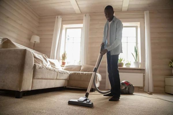 African American man use vacuum cleaner hovering house — Stock Photo, Image