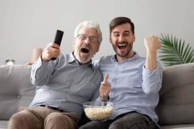 Overjoyed yaşlı baba ve genç oğlu tv spor oyunu izlerken