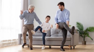 Mutlu üç nesil erkek aile oturma odasında birlikte dans