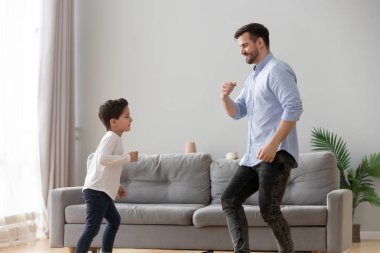 Mutlu baba ve çocuk oğlu oturma odasında birlikte dans