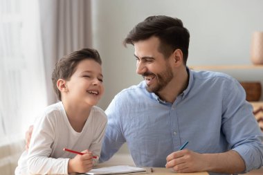 Mutlu baba ve küçük çocuk oğlu birlikte çizim gülüyor