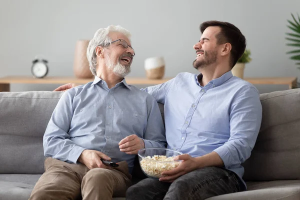 Heureux deux générations mâle famille rire profiter parler regarder la télévision — Photo