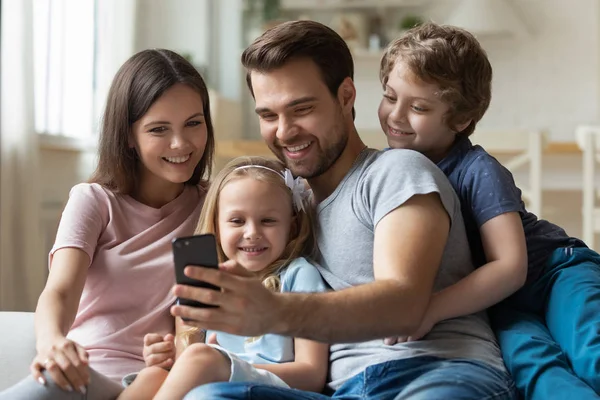 Glücklicher junger Mann macht Selfie mit Frau und Kindern. — Stockfoto