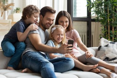 Joyful aile akıllı telefonda selfie çekimi yapıyor.