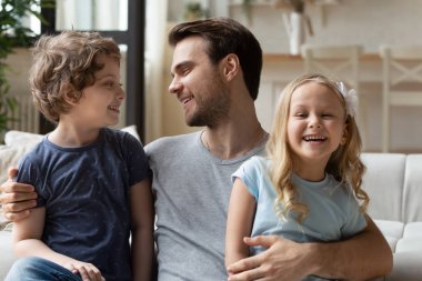 Mutlu genç bekar baba iki küçük çocuk sarılma.