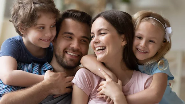 Hlavní záběr zblízka rodinný portrét pozitivní rodiče objetí dětí. — Stock fotografie