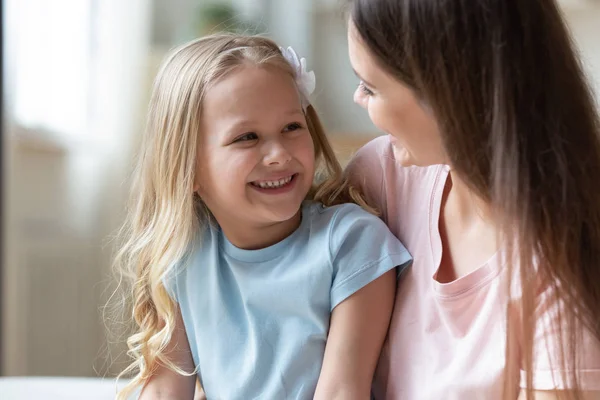 Счастливая очаровательная маленькая дошкольница разговаривает с позитивной мамой . — стоковое фото