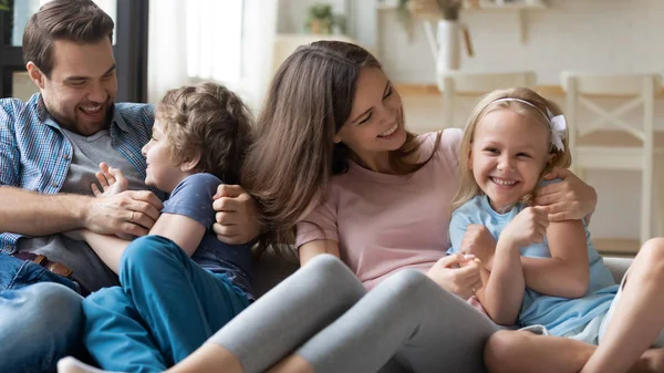 Evde kanepede birlikte oynayan overjoyed heyecanlı aile. — Stok fotoğraf