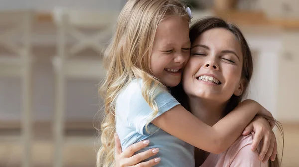 Adorável loira adotada menina abraçando mamãe . — Fotografia de Stock