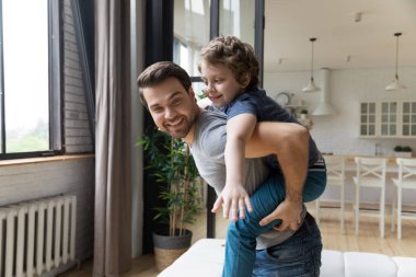 Mutlu baba sevimli oğluna piggyback binmek veren.