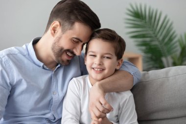 Sevecen baba ve çocuk oğlu bağ kucaklayan kanepeye otur