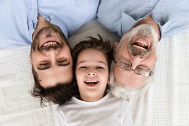 Mutlu üç nesil aile satırda yalan, portre, closeup görünümü
