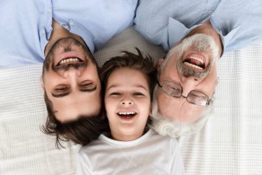 Happy three generation family lying in row, portrait, closeup view clipart