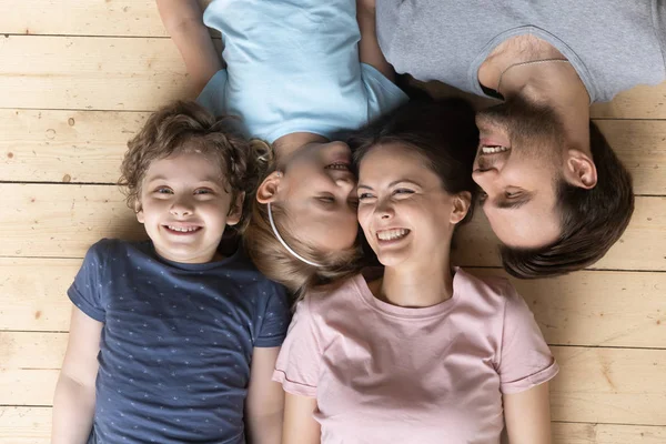 Top above view joyful family lying on heated warm floor. — Stock Photo, Image