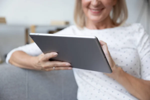 Smiling mature woman using computer tablet close up — Stock Photo, Image