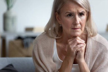 Üzgün olgun kadın tek başına oturan, düşünme, rahatsız hissetme
