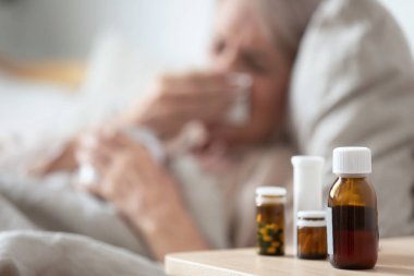 Sağlıksız olgun kadın soğuk muzdarip, başucu masada meds