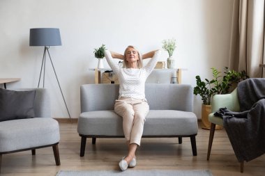 Sakin yaşlı olgun kadın evde rahat kanepe üzerinde rahatlatıcı