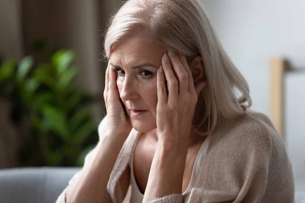 Ältere Frau berührt Schläfen, fühlt sich schlecht, psychische Störung — Stockfoto