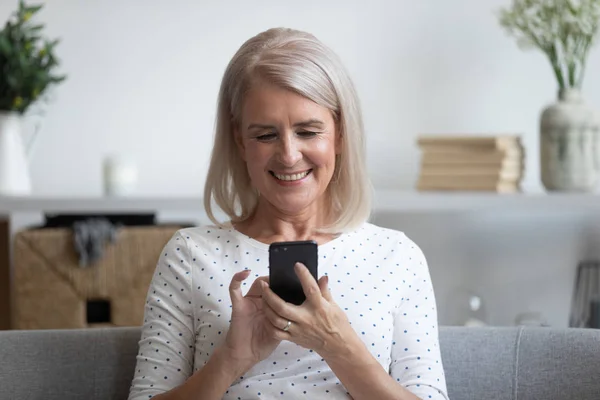 Sorrindo mulher madura segurando telefone, usando aplicativos de dispositivo móvel — Fotografia de Stock