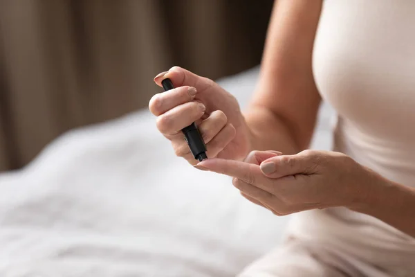 Volwassen vrouw met behulp van bloedglucose meter close-up — Stockfoto