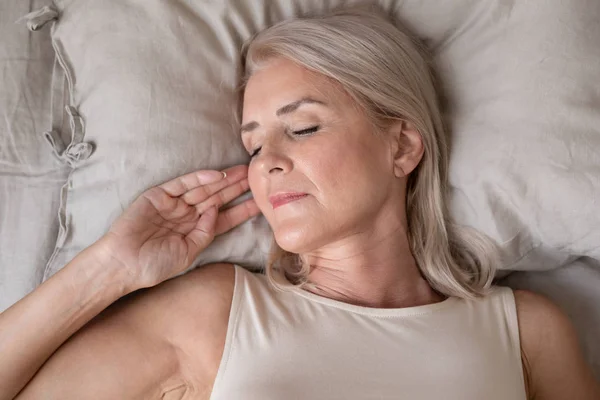 Peaceful beautiful mature woman sleeping in bed close up — Stock Photo, Image