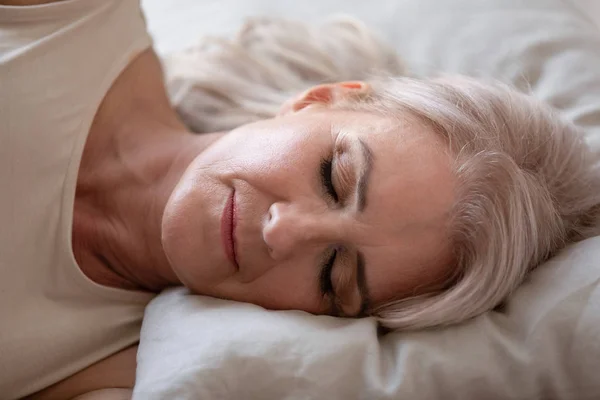 Entspannt schön reif frau schlafen im bequemen bett close up — Stockfoto