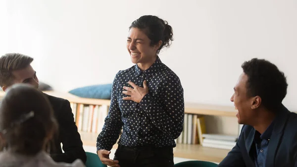 Happy funny indian woman business leader and diverse team laughing