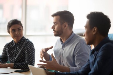 Kafkasyalı ciddi iş adamı Hintli Afrikalı insanlarla konuşuyor.