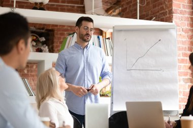 Erkek sunucu brifingde resim sunumu yapıyor