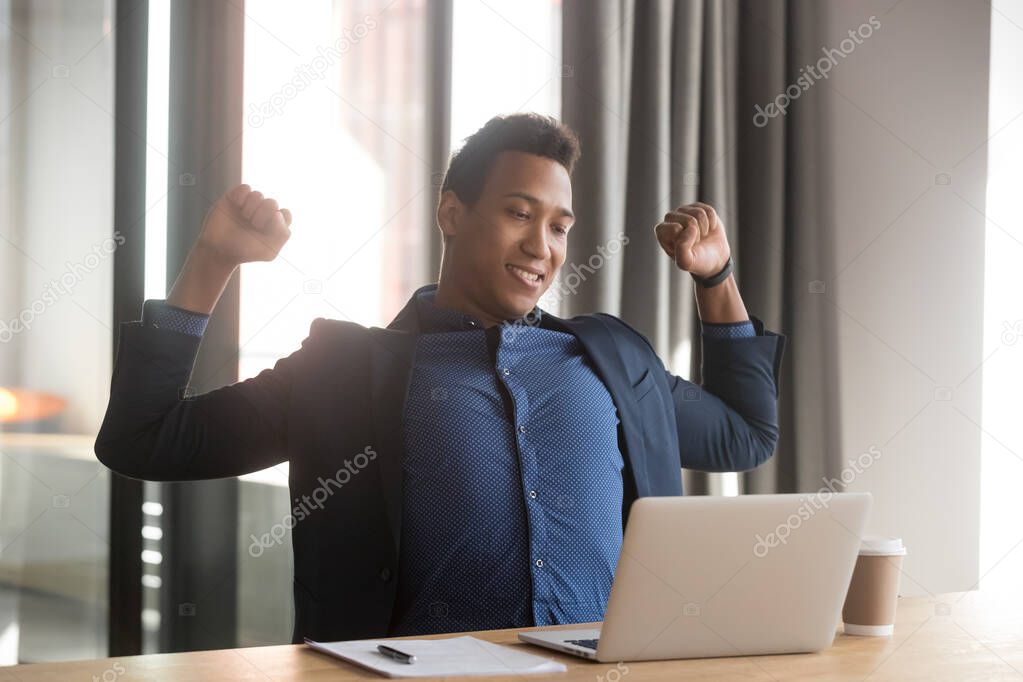 Relaxed happy african american business man stretching at work break