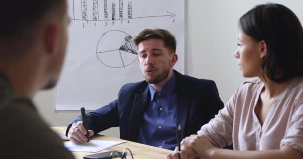 Zelfverzekerde mannelijke leider praten met multiraciale team bieden project idee — Stockvideo