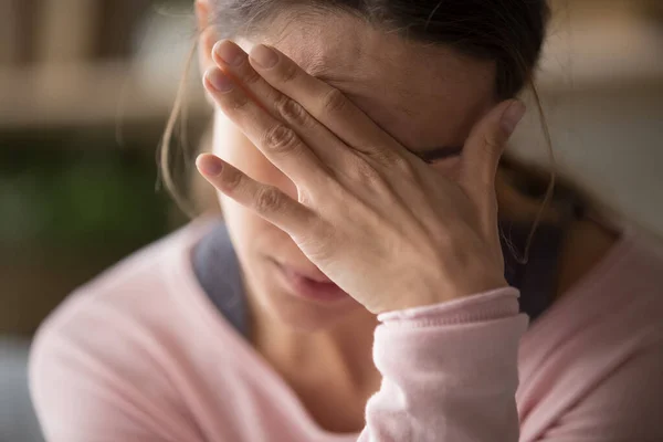 Üzgün, yorgun bir kadın yüzüne dokunuyor. Baş ağrısı ya da depresyon geçiriyor. — Stok fotoğraf