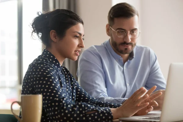 Pasante masculino enfocado escuchando mentor indio explicando estrategia en línea —  Fotos de Stock