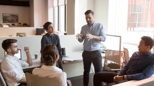 Serieuze teamleider praat met diverse zakenmensen op bijeenkomst — Stockfoto