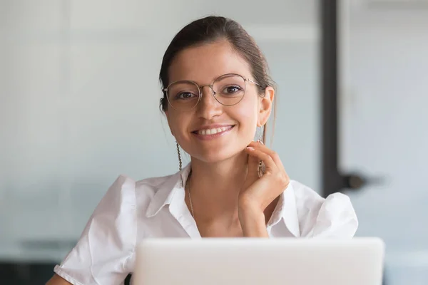 Sorridente giovane donna d'affari che indossa occhiali in posa sul posto di lavoro — Foto Stock