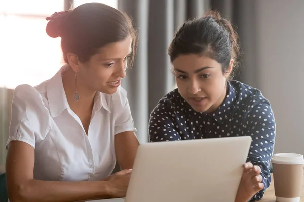 Centrado diversa etnia compañeras de trabajo equipo brainstorming apuntando a la computadora portátil — Foto de Stock