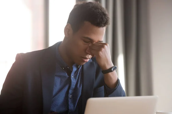 Frustrado estresado empresario negro siente dolor de cabeza tensión ocular en el trabajo — Foto de Stock